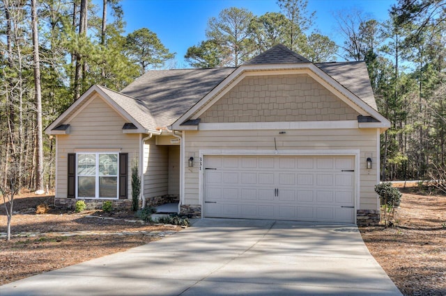 view of front of house featuring driveway, a shingled roof, an attached garage, and stone siding