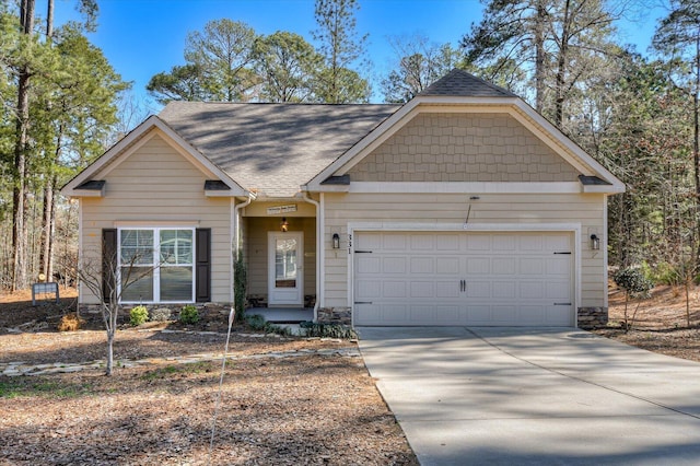 craftsman-style house featuring an attached garage, driveway, and roof with shingles