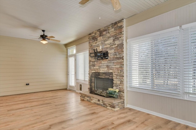 unfurnished living room with a fireplace, a ceiling fan, and wood finished floors