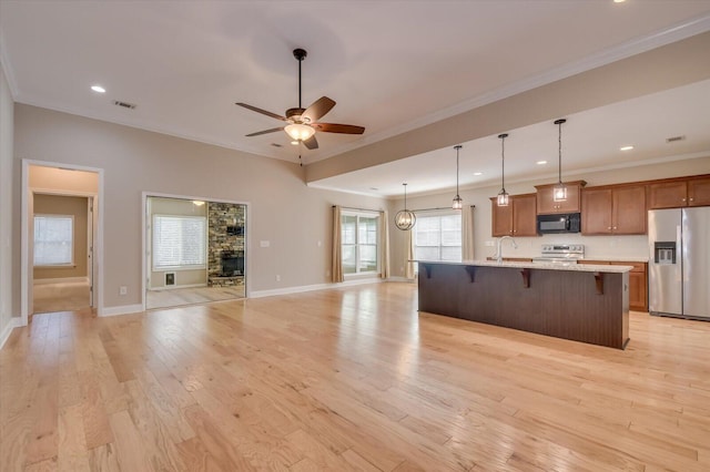 kitchen featuring a breakfast bar, visible vents, appliances with stainless steel finishes, and open floor plan