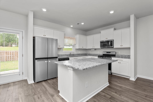 2965 Calli Crossing Dr, Graniteville, SC 29829 - kitchen with appliances with stainless steel finishes, a kitchen island, white cabinets, dark wood finished floors, and light stone counters