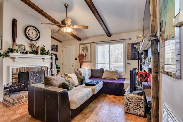 living room with ceiling fan, lofted ceiling with beams, a brick fireplace, and light parquet floors