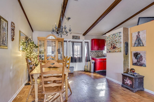 dining space with parquet flooring, lofted ceiling with beams, and a chandelier