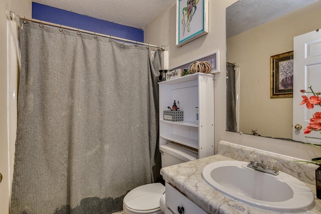 bathroom featuring toilet, vanity, and a textured ceiling