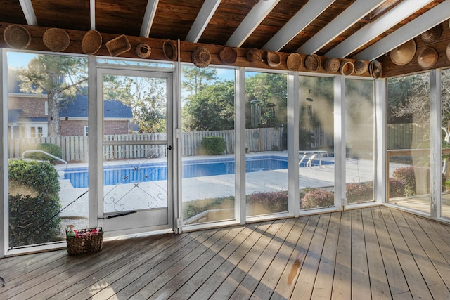 unfurnished sunroom featuring vaulted ceiling with beams