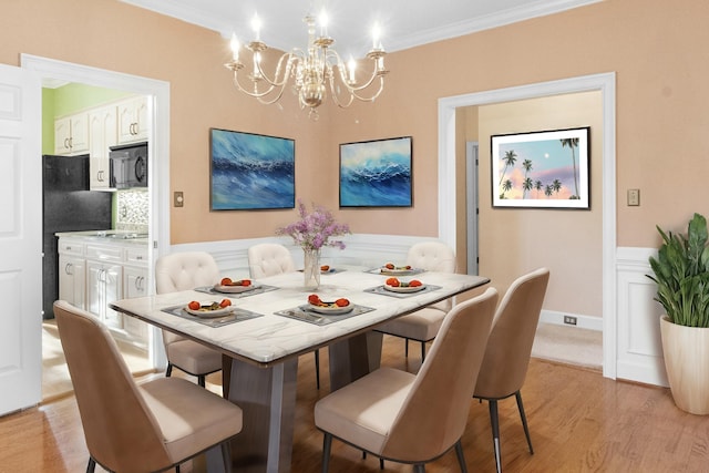 dining room with crown molding, light hardwood / wood-style flooring, and a chandelier