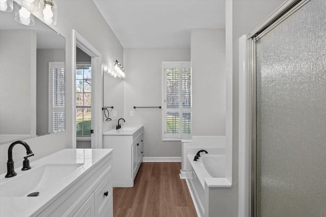 bathroom with hardwood / wood-style floors, vanity, and independent shower and bath