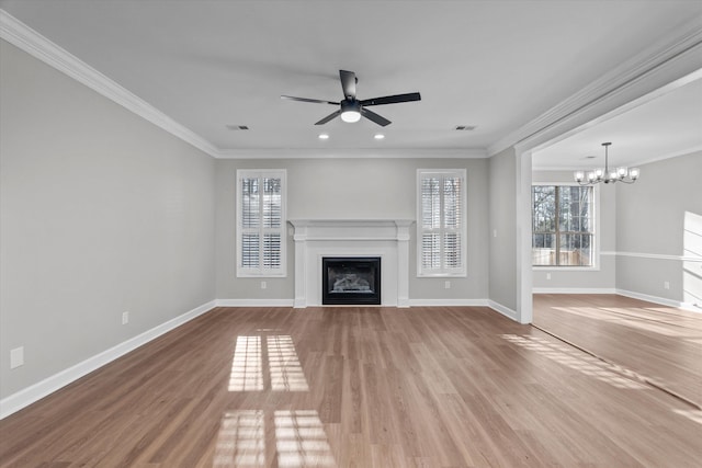 unfurnished living room featuring hardwood / wood-style floors, ceiling fan with notable chandelier, and crown molding