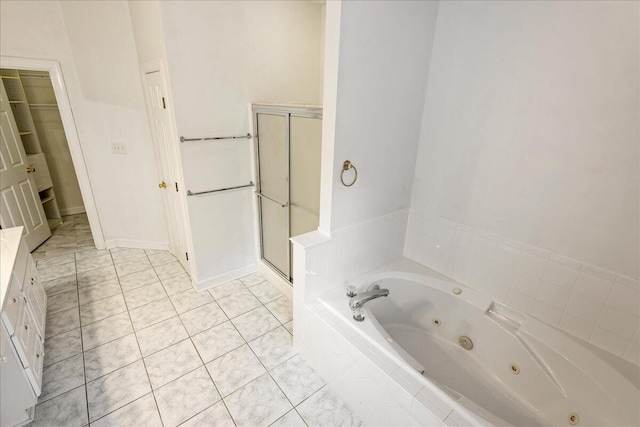 bathroom with a shower stall, a jetted tub, tile patterned flooring, and vanity