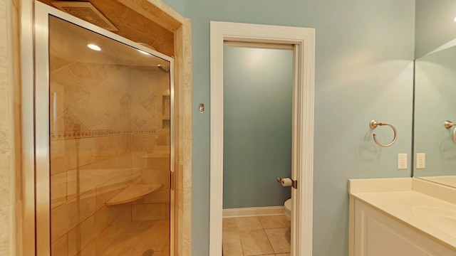 bathroom with a shower with door, toilet, tile patterned floors, and vanity