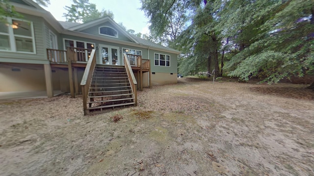 rear view of property featuring a wooden deck