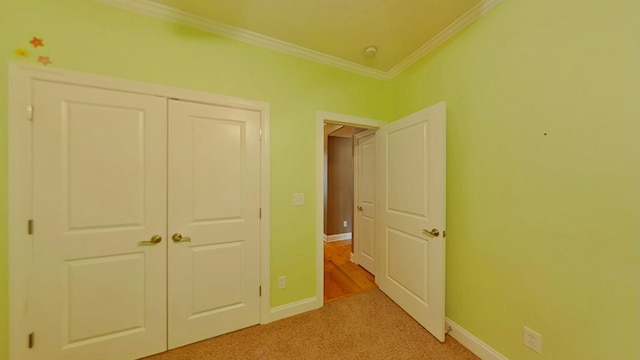 unfurnished bedroom featuring a closet, light colored carpet, and crown molding