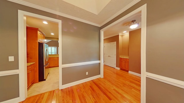 empty room featuring light hardwood / wood-style floors and crown molding