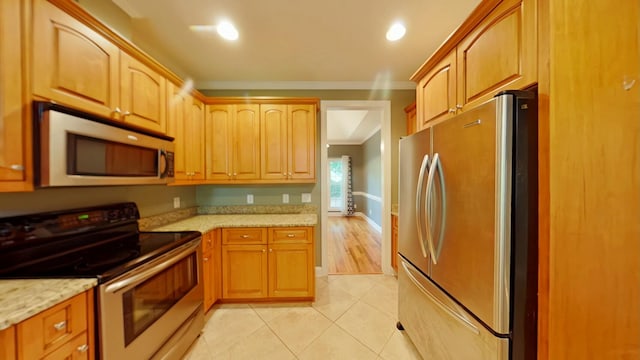 kitchen featuring light stone countertops, light tile patterned floors, crown molding, and appliances with stainless steel finishes