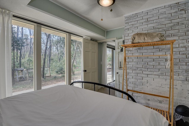 unfurnished bedroom with access to outside, brick wall, and a textured ceiling