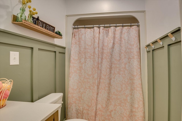 bathroom with a shower with curtain and toilet