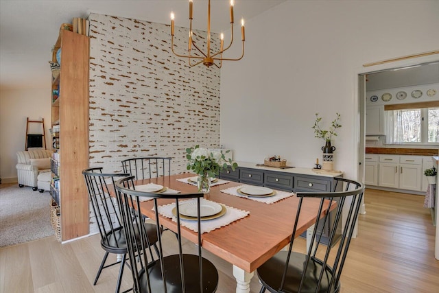 dining space featuring light wood-type flooring and an inviting chandelier