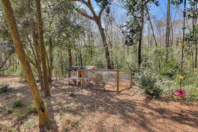 view of yard with a view of trees, an outdoor structure, and exterior structure