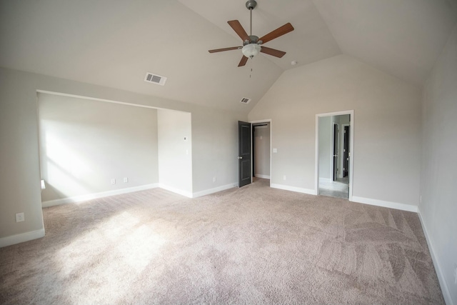 spare room with high vaulted ceiling, baseboards, visible vents, and light colored carpet