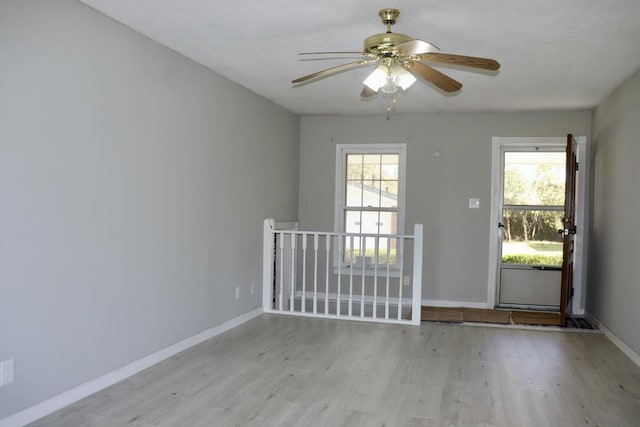 interior space featuring baseboards, light wood-style floors, and ceiling fan