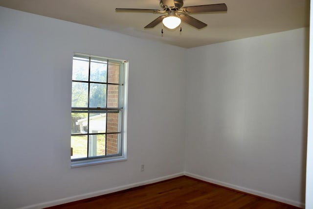 empty room featuring wood finished floors, baseboards, and ceiling fan