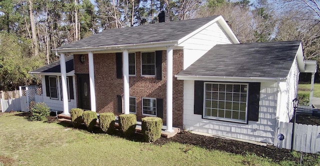 view of front of house featuring a front lawn, fence, roof with shingles, and a chimney