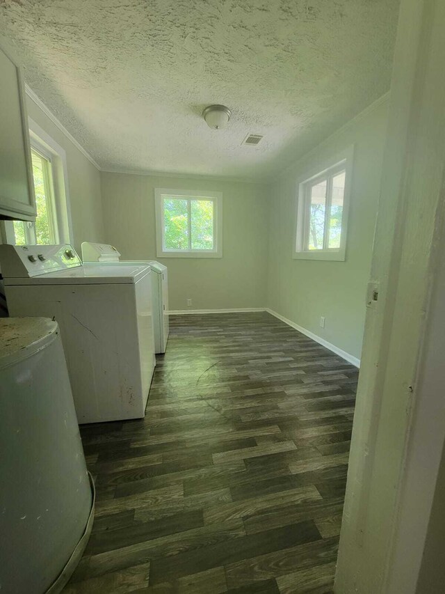 washroom with dark hardwood / wood-style flooring, washing machine and dryer, and a textured ceiling