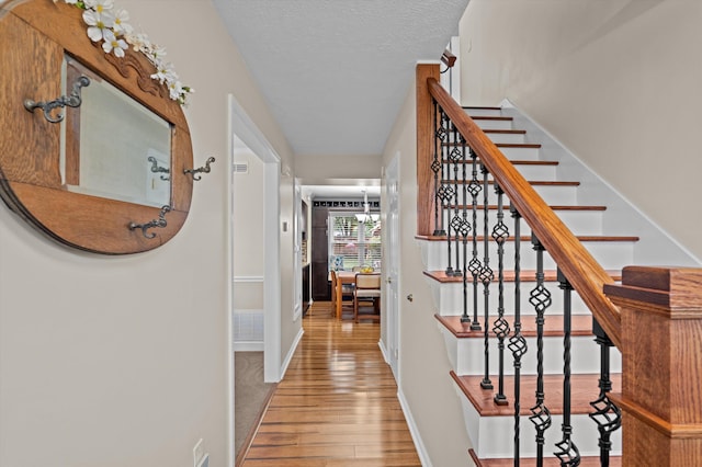 492 Pheasant Run Dr, Evans, GA 30809 - staircase with hardwood / wood-style floors, baseboards, and a textured ceiling