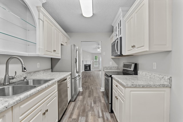55 Charlestowne Dr, Augusta, GA 30907 - kitchen featuring stainless steel appliances, a ceiling fan, light wood-style flooring, a fireplace, and white cabinets