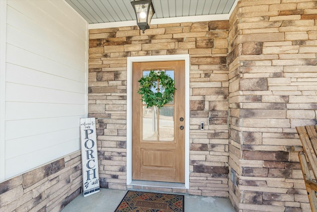 property entrance featuring stone siding and brick siding