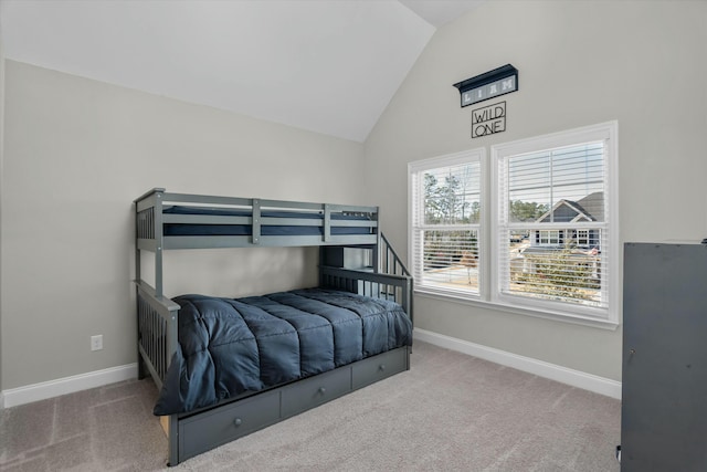 carpeted bedroom with vaulted ceiling and baseboards