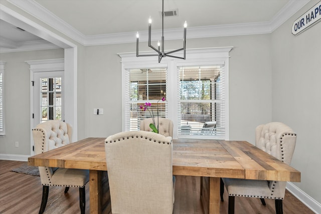 dining room featuring a chandelier, wood finished floors, visible vents, baseboards, and ornamental molding