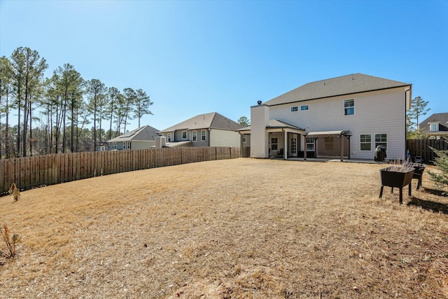 rear view of property featuring a patio area, a fenced backyard, and a yard