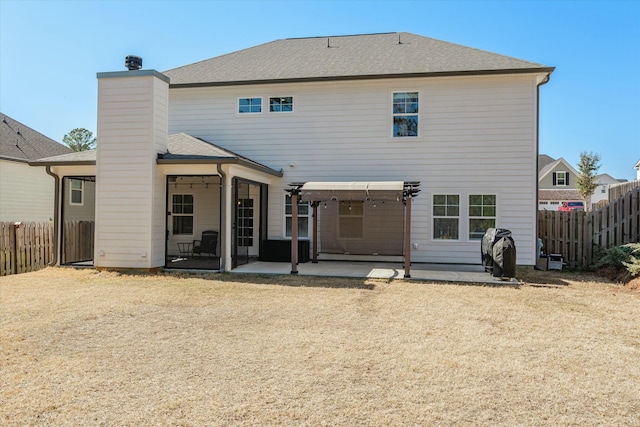 back of property with a chimney, a patio area, and fence