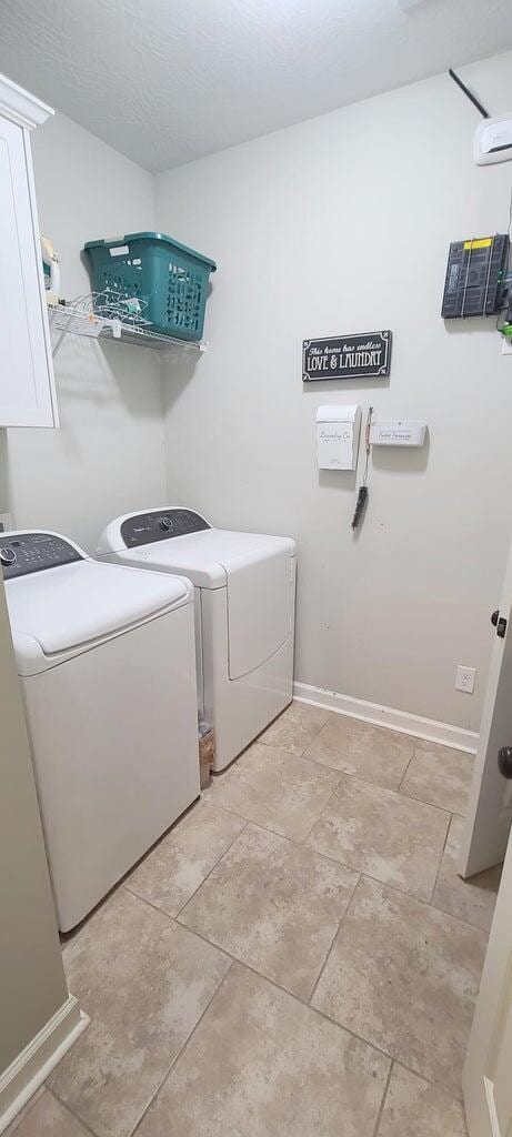 laundry room featuring cabinets and washer and dryer