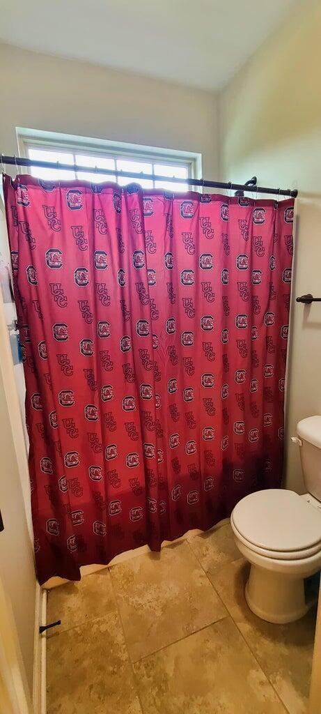 bathroom with tile patterned floors, toilet, and a shower with shower curtain