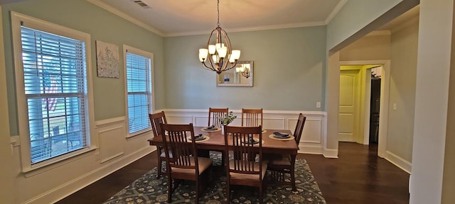 dining space featuring an inviting chandelier, crown molding, and dark hardwood / wood-style flooring