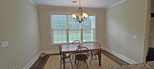 dining space featuring dark hardwood / wood-style flooring, crown molding, and a chandelier