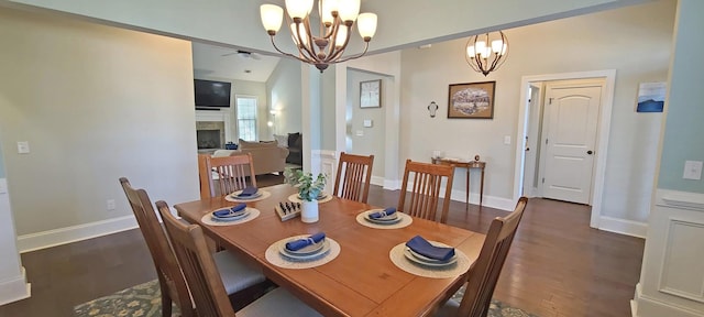 dining area with dark hardwood / wood-style flooring, ceiling fan with notable chandelier, and vaulted ceiling