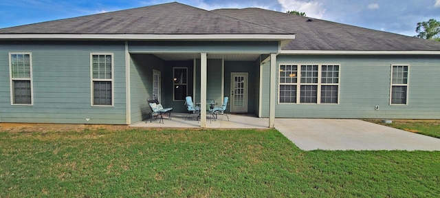 rear view of house with a patio area and a lawn