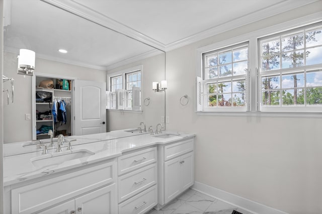full bath with a sink, baseboards, and crown molding