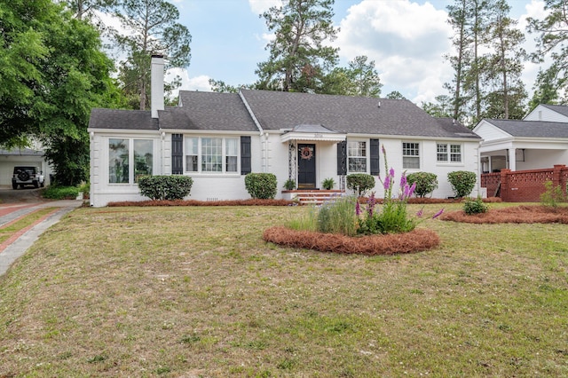 ranch-style house with a chimney and a front yard