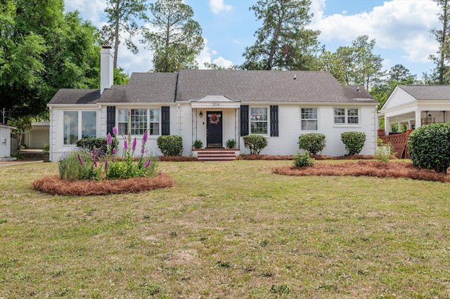 single story home featuring a chimney and a front lawn