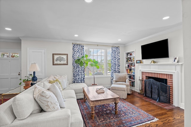 living room with ornamental molding, a brick fireplace, and recessed lighting