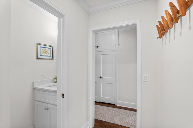 hallway with crown molding, dark wood-style flooring, and baseboards