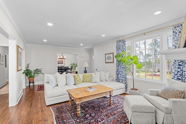 living room featuring crown molding, an inviting chandelier, recessed lighting, baseboards, and wood finished floors