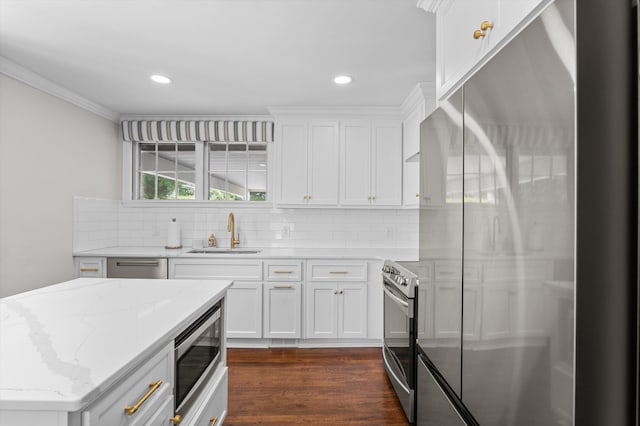 kitchen with ornamental molding, dark wood-style floors, a sink, backsplash, and stainless steel appliances