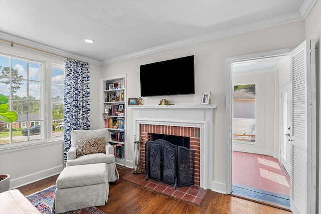sitting room featuring a fireplace, wood finished floors, baseboards, ornamental molding, and recessed lighting