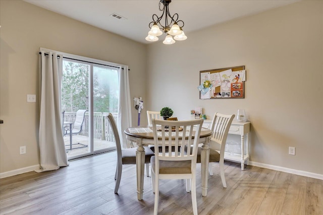 dining space featuring a notable chandelier and light wood-type flooring