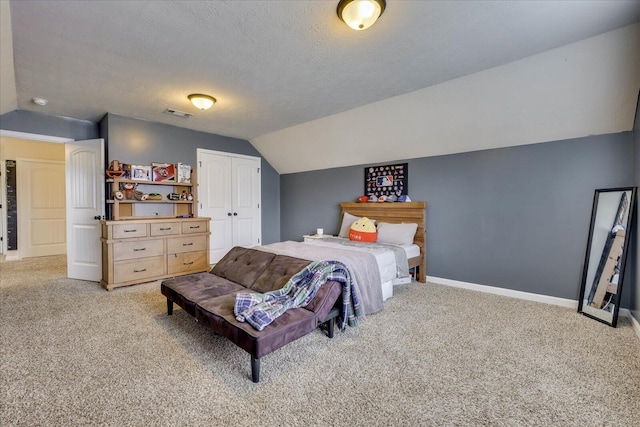 bedroom featuring a textured ceiling, light colored carpet, and lofted ceiling